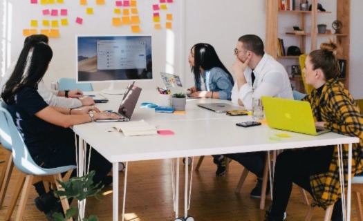 People sitting around a table looking at a computer