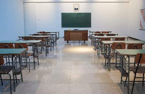 Empty classroom with desks and chalkboard