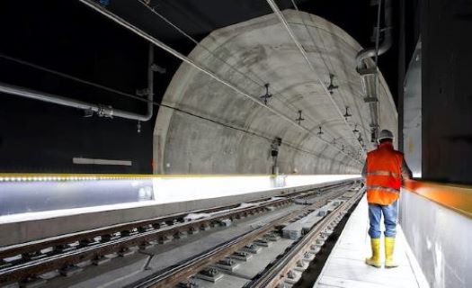 A working standing in a subway tunnel. 
