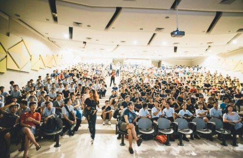 Image of a filled auditorium, taken from the stage looking out onto the seats