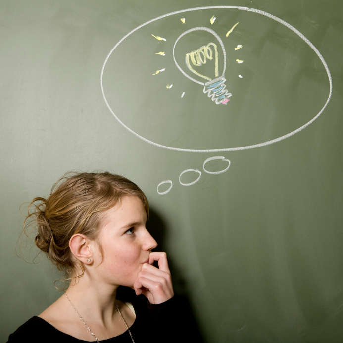 Light bulb drawn on blackboard above woman's head