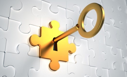 Gold key in lock made of puzzle pieces