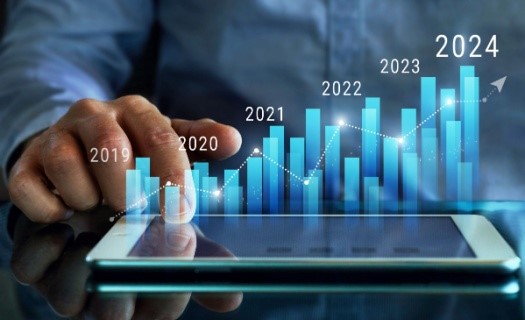 A man's hand over a tablet with data rising out of it showing trends over time