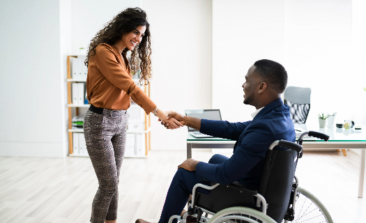Woman shaking hands with a man in a wheelchair