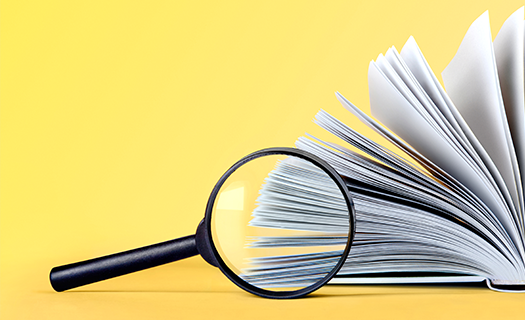 glass-magnifying-loupe-book-on-background