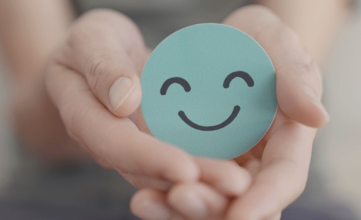 Hand holding smiling face