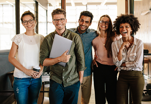 Five young people standing together smiling