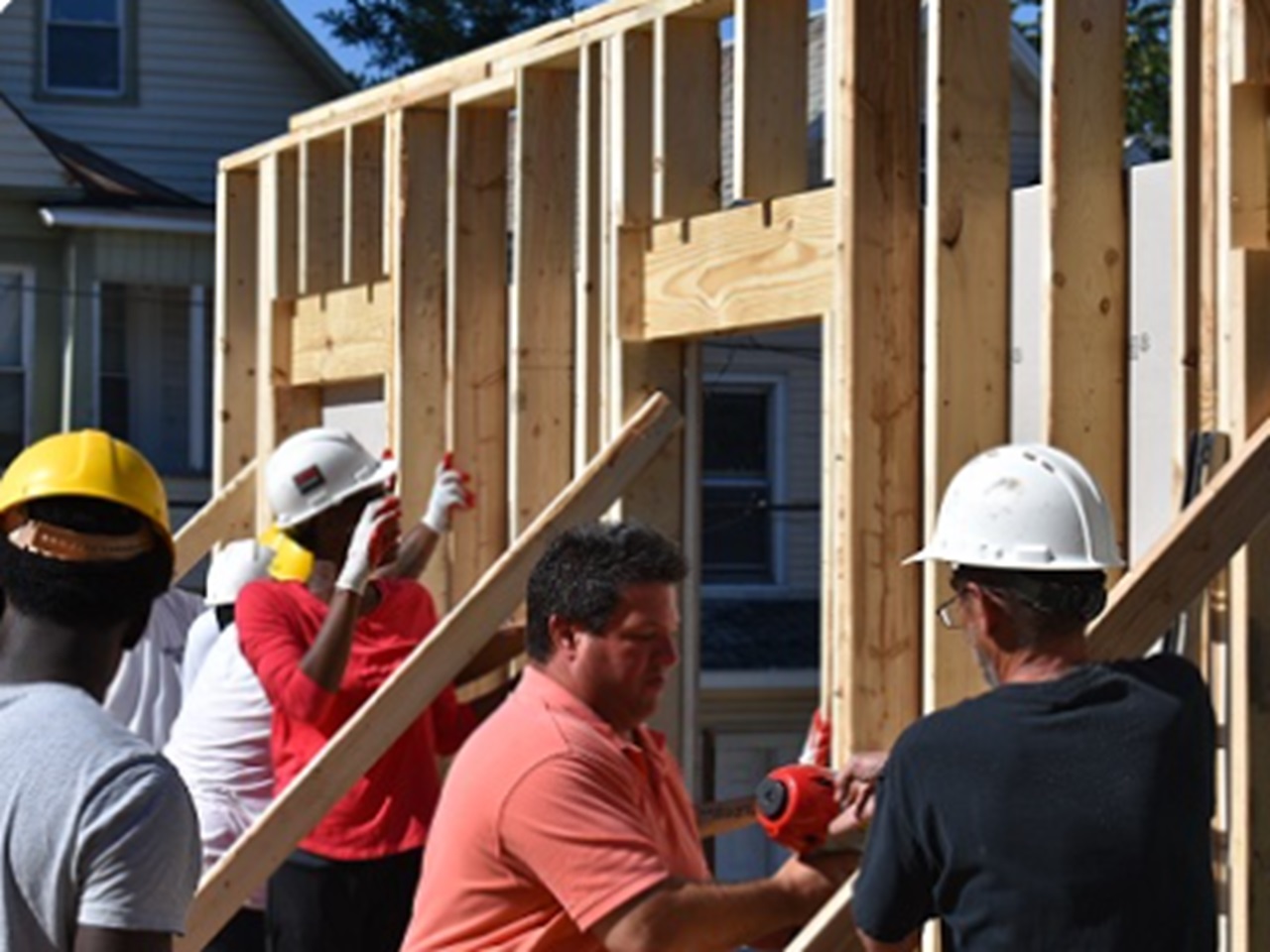 Construction workers frame a house