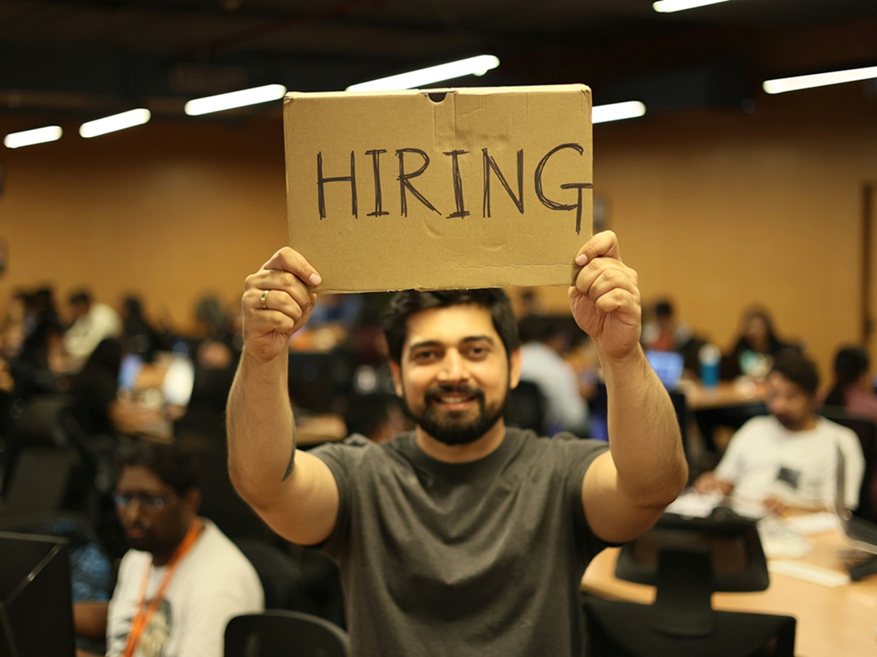 man holds hiring sign