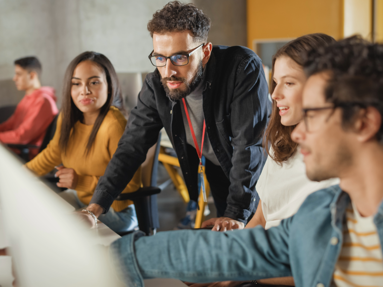 Teacher leans in to answer student question on computer