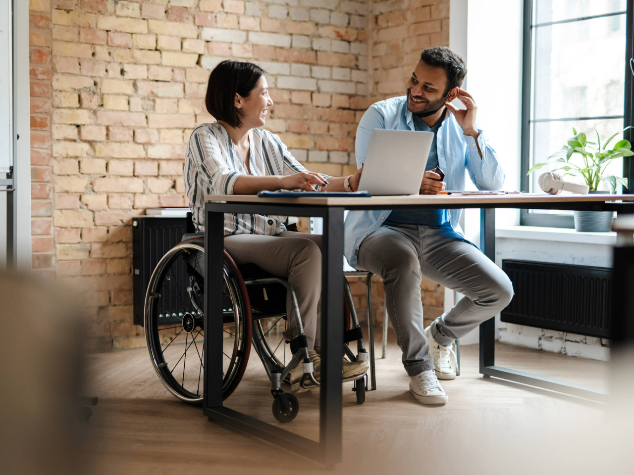 Colleagues smiling and speaking with one another 