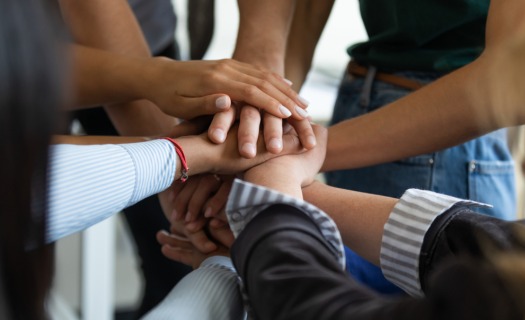 Professionals with their hands in a stack for a huddle