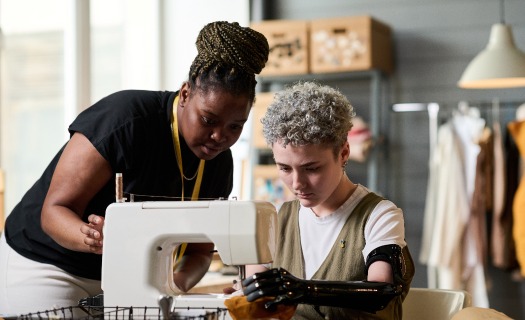 two-young-female-specialists-sewing-clothes