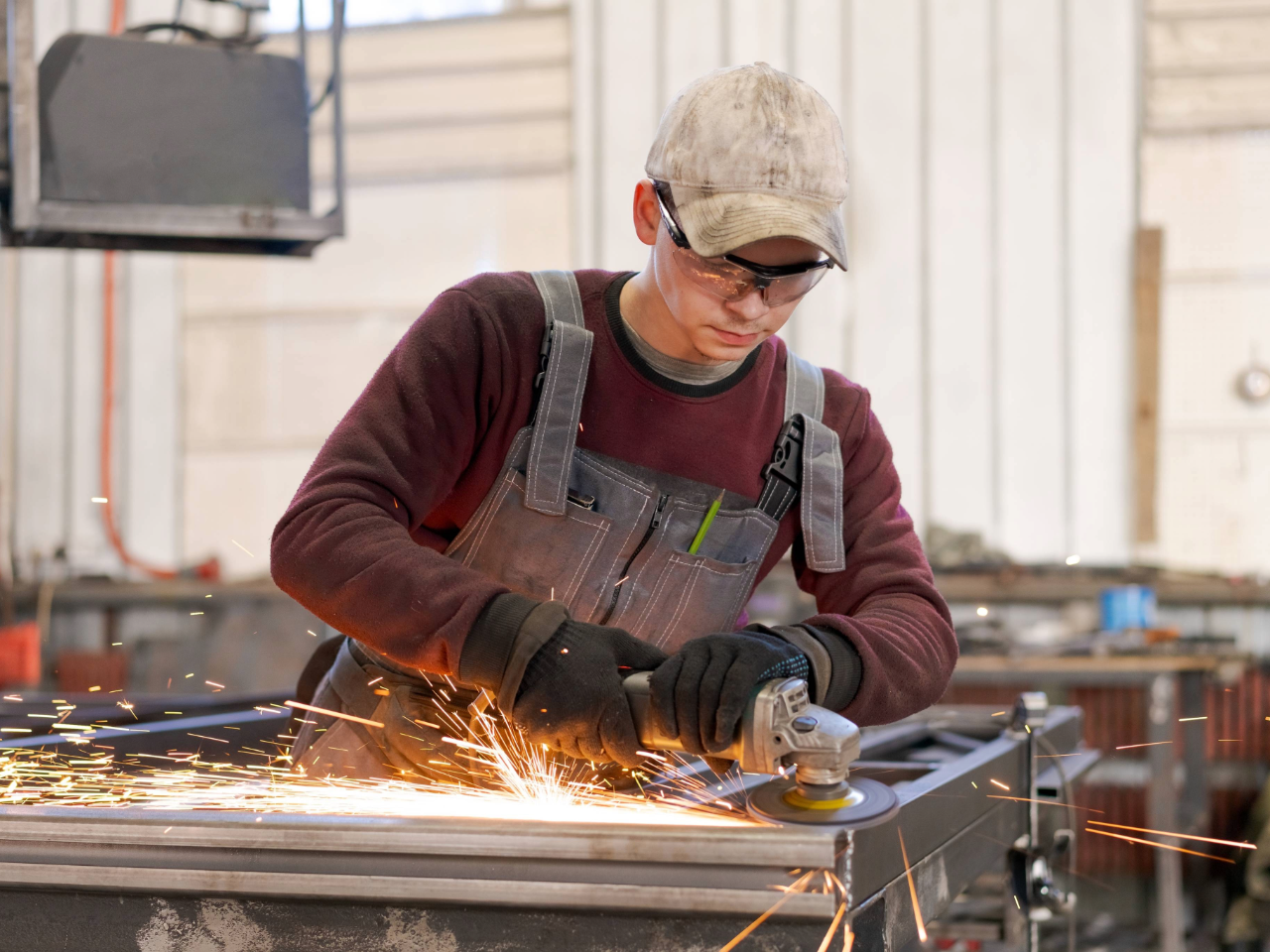 Apprentice uses power tool with PPE