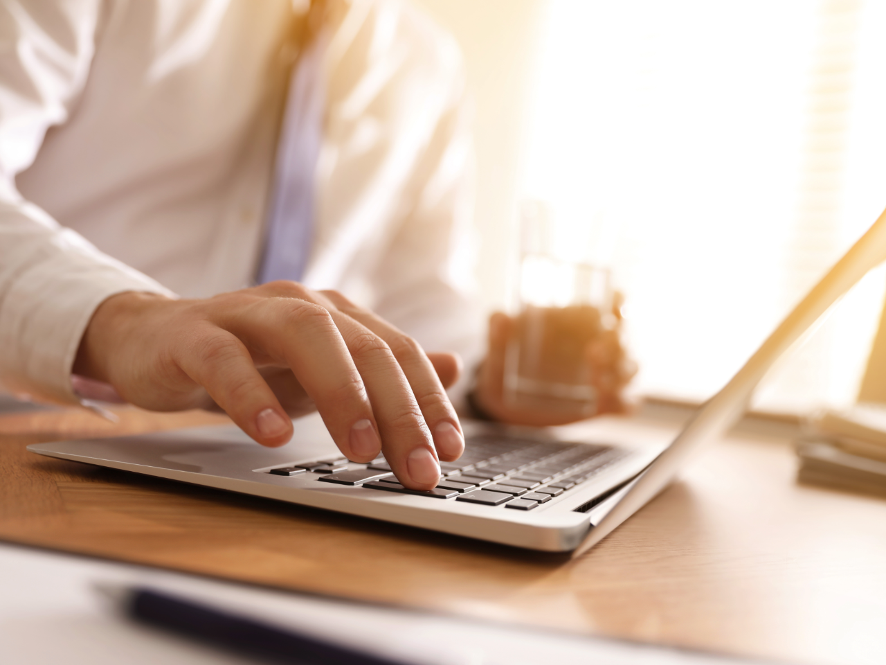 businessman types on laptop