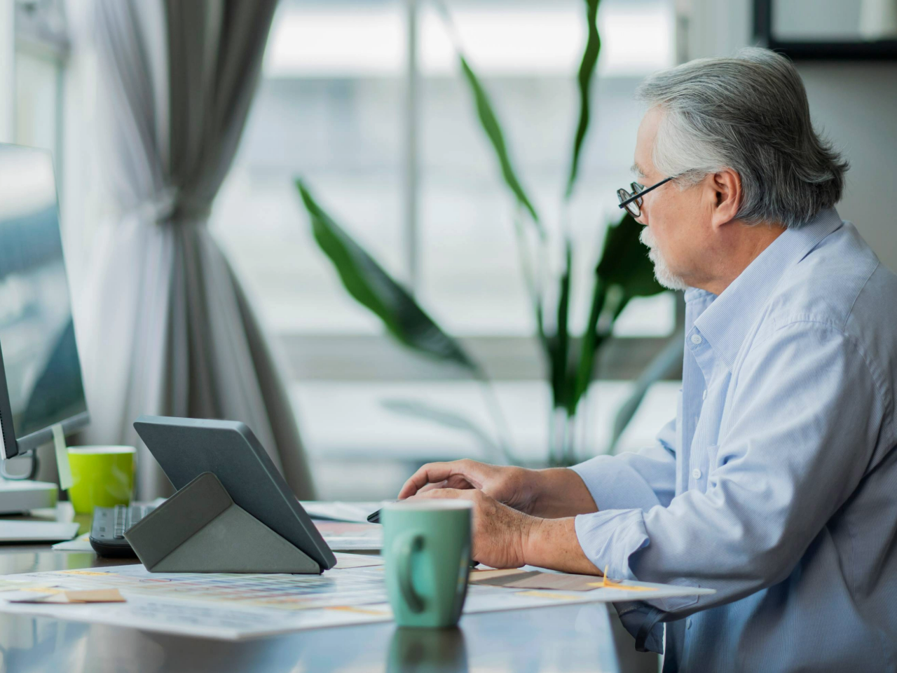Side view of older worker at desk working