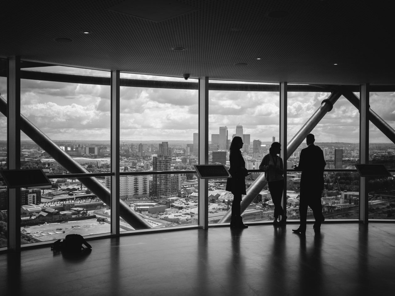 People meeting in front of a large window in front of a skyline, representing business collaboration and workforce development.